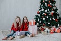 Two blonde girlfriends sisters girls Christmas presents new year tree Royalty Free Stock Photo