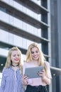 Two blonde students friends laughing using mobile phone and tablet Royalty Free Stock Photo