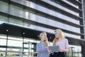 Two blonde students friends laughing using mobile phone and tablet Royalty Free Stock Photo