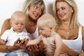 Two blondies women and two babies Royalty Free Stock Photo