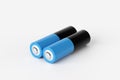 Two blue and black batteries lying on white background Royalty Free Stock Photo