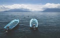 Two blue boats on lake Atitlan with view on volcanoes San Pedro and Toliman in Santa Cruz la Laguna, Guatemala Royalty Free Stock Photo