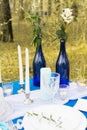 Two blue bottles such a vase with flowers on a banquet table. Decoration Royalty Free Stock Photo