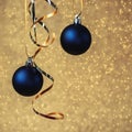 Two blue christmas balls on golden bokeh background. Minimal winter composition. New Year concept Royalty Free Stock Photo
