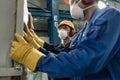 Two blue-collar workers wearing protective equipment