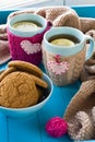Two blue cup of tea in knitted sweater with hearts felt