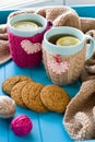 Two blue cup of tea in knitted sweater with hearts felt standing