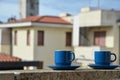 Two blue cups of coffee with panoramic view of a city in background. on the balcony against the backdrop of the old Royalty Free Stock Photo