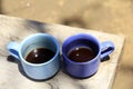 Two blue cups of coffee on rustic wooden table. Morning coffee concept with coffee cup outdoor background.