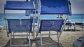 Two blue deckchairs on the sand of the Italian beach Royalty Free Stock Photo