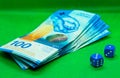 Two blue dices next to money bills with a green background Royalty Free Stock Photo