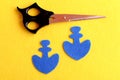 Two blue felt anchor, scissors on yellow background. Sewing hobby for children, women, beginners. Step. Top view Royalty Free Stock Photo