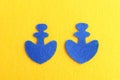 Two blue felt anchor on yellow background. Sewing crafts for children, women, beginners. Step. Top view Royalty Free Stock Photo