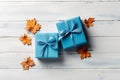 Two blue gift boxes with silver glitter ribbon bow and maple leaves isolated on rustic plae blue wooden background, top view, Royalty Free Stock Photo