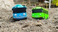 two blue and green toy buses are on the sand Royalty Free Stock Photo