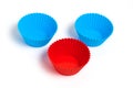 Two blue and one red silicone molds for baking a cupcake on a white background Royalty Free Stock Photo