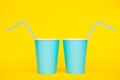 Two Blue Paper Cups With Drinking Colored Plastic Straws On Yellow Background. Set For Party. Minimalist Style. Copy, Empty Space