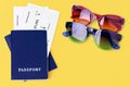 Two blue passports, boarding pass, flight ticket, sunglasses on yellow background, airplane travel, summer holidays, vacation Royalty Free Stock Photo