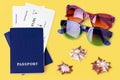 Two blue passports, boarding pass, sunglasses, seashells yellow background, flight ticket, travel, summer holidays, vacation, tour Royalty Free Stock Photo