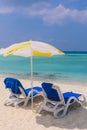 Two Blue Plastic Chaise Lounges under Yellow Umbrella on the Local Bikini Beach of the Maafushi Island Royalty Free Stock Photo