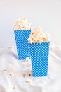 Two blue popcorns buckets with dots isolated on white full of popcorns. Cinema and theatre promo