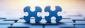 Two Blue Puzzle Pieces on Keyboard Two blue puzzle pieces connected sitting on a keyboard representing solutions teamwork or Royalty Free Stock Photo