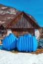 Two blue rainwater tanks in front of wooden shed in Slovenia Royalty Free Stock Photo