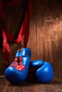 Two blue and red boxing gloves and red bandage against wooden background. Royalty Free Stock Photo