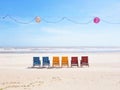 Colourful beach chairs on a wide white sand beach facing the ocean in Vietnam with lampions and a light chain above