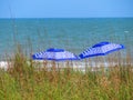 Two blue striped umbrellas on beach Royalty Free Stock Photo