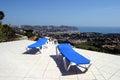 Two blue sunbeds on terrace in the sun with amazing views of the ocean