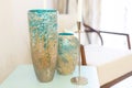 Two blue textured vases in the interior. They stand on a shelf in the living room, along with a hanging and candles