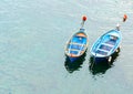 Two blue traditional style fishing dinghies moored in sea