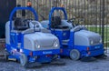 two blue urban hygiene vehicles for cleaning the public road stopped without a driver, Rome, Italy.