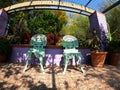 Two blue wrought iron chairs in botanic garden