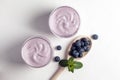 Two blueberry yogurt with blueberries on a white texture table, top view Royalty Free Stock Photo