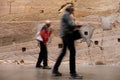 Two blurred persons walking along the sandstone wall in MONA in Hobart, Tasmania
