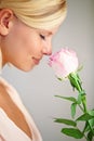 Two blushing blossoms. Profile of a young woman smelling a pink rose. Royalty Free Stock Photo