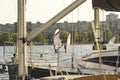 Two boards with a sail on the background of urban houses and yachts