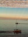 Two boats crossing around on the Adrian sea with clouds and sunset