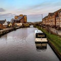 Boats docked in a canal with houses in the background Royalty Free Stock Photo