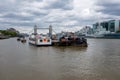 Boats docked in the river themes, London bridge can be seen in the distance.