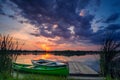 Two boats on a lake near a pontoon at sunrise with dramatic clouds Royalty Free Stock Photo