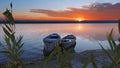 Two boats stand at the shore of a calm river against the background of a bright rising sun Royalty Free Stock Photo