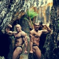 Two bodybuilders posing outdoors - copyspace