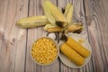 Two boiled ears of corn, corn kernels, coarse salt and raw ears of corn on a wooden table. Fitness diet. Healthy diet. For a sweet Royalty Free Stock Photo