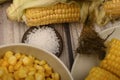 Two boiled ears of corn, corn kernels, coarse salt and raw ears of corn on a wooden table. Fitness diet. Healthy diet. For a sweet Royalty Free Stock Photo