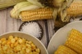 Two boiled ears of corn, corn kernels, coarse salt and raw ears of corn on a wooden table. Fitness diet. Healthy diet. For a sweet Royalty Free Stock Photo