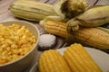 Two boiled ears of corn, corn kernels, coarse salt and raw ears of corn on a wooden table. Fitness diet. Healthy diet. For a sweet Royalty Free Stock Photo