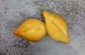 Two bolillo bread rolls on a gray mottled background